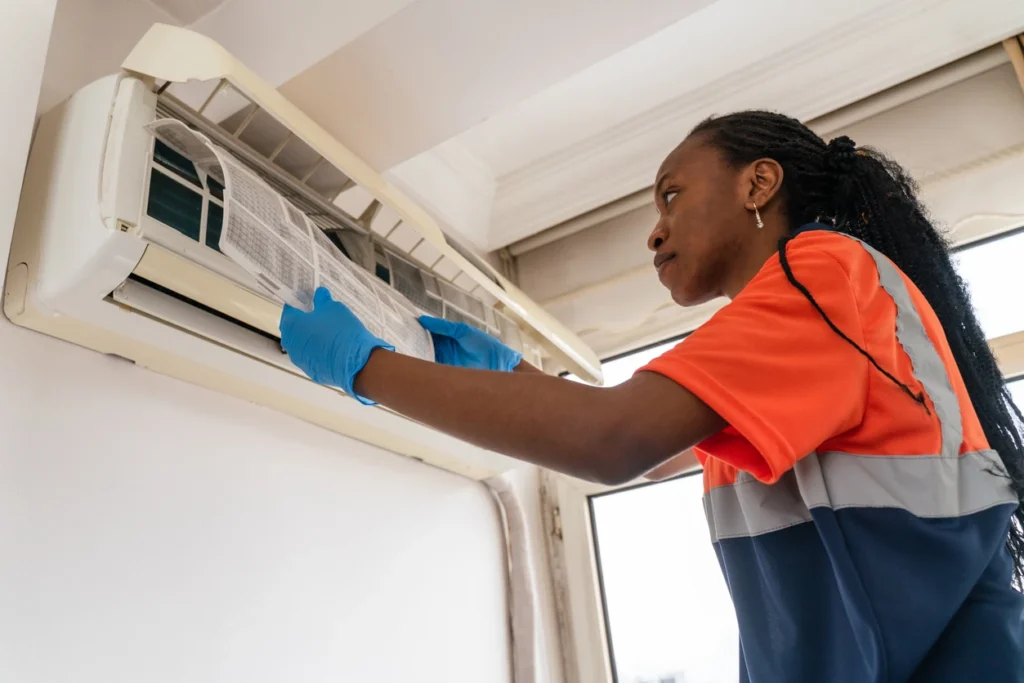 A woman is diligently cleaning an air conditioner