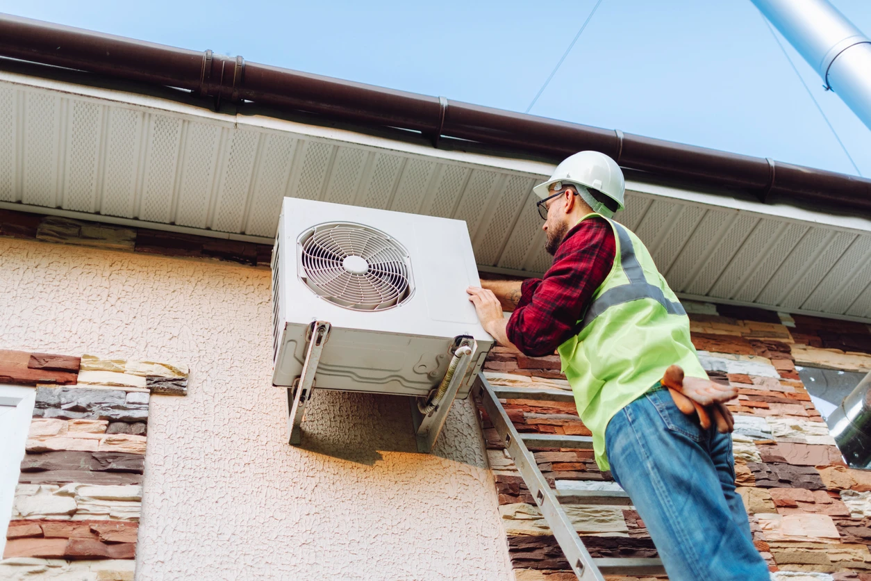 A technician is fixing an air conditioner