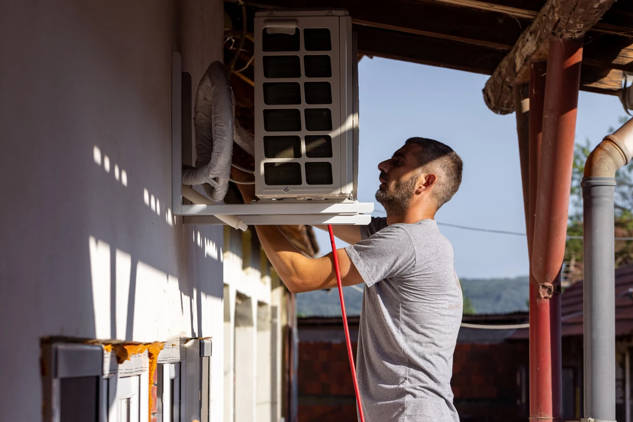 A man is engaged in repairing an air conditioning system