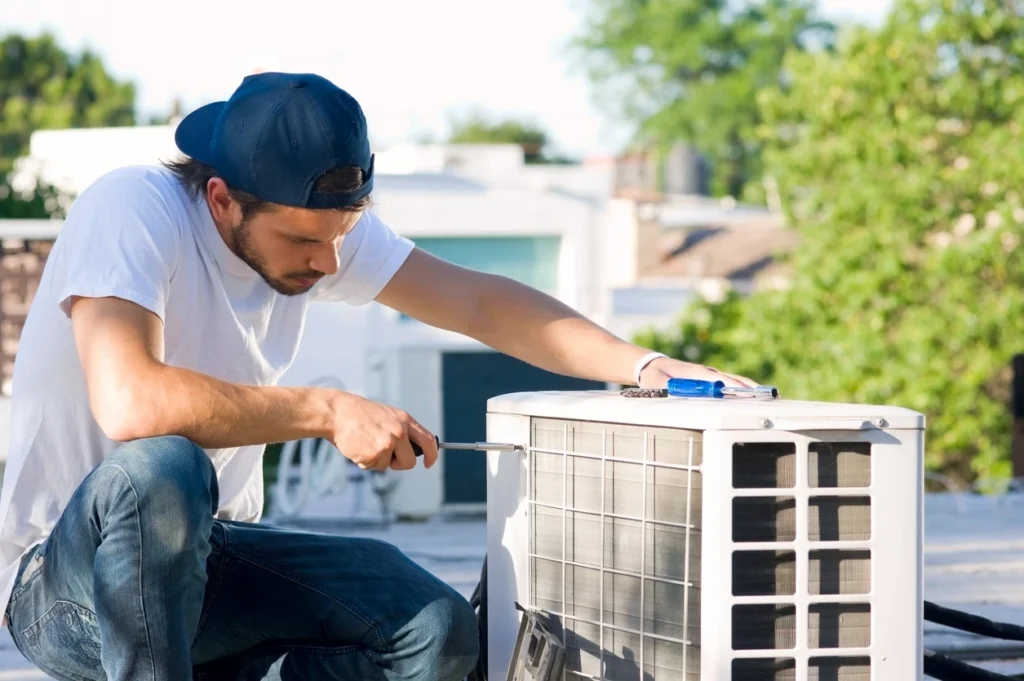 A technician is fixing an air conditioner