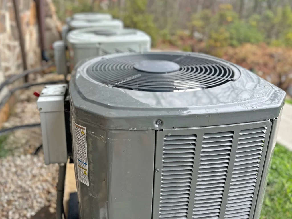 Three air conditioning units placed on a wooden pallet