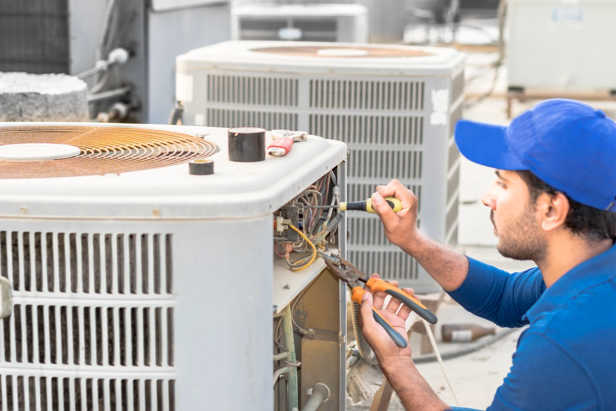 A technician is servicing an air conditioner