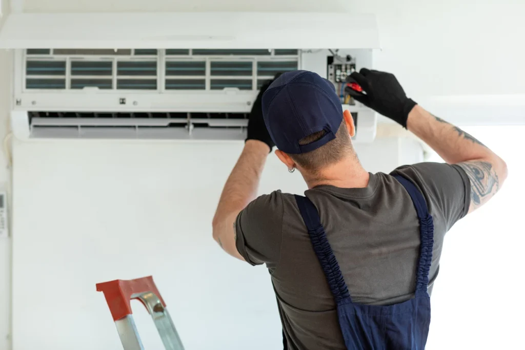 A technician is servicing an air conditioner